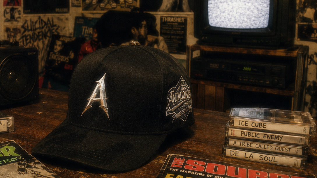 Antagonist cap in an 80s setting room with walls filled with posters, cap on top of desk with hip hop music cassettes  